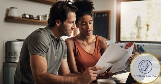 Husband and wife looking at papers and having a discussion in their kitchen.